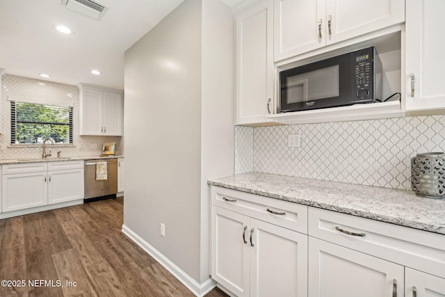 4580 Carolyn Cove Ln N, Jacksonville, FL 32258 - kitchen featuring dishwasher, black microwave, backsplash, dark wood-style floors, and white cabinets