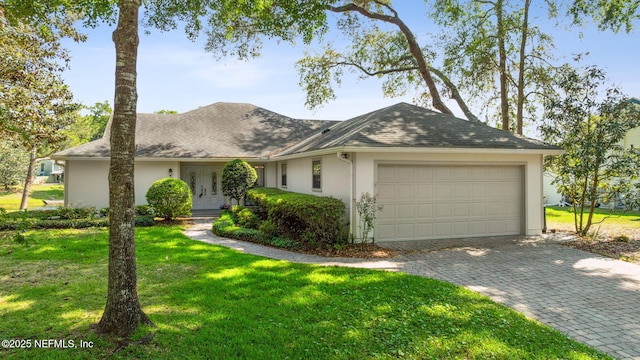 4580 Carolyn Cove Ln N, Jacksonville, FL 32258 - view of front of home featuring an attached garage, a front yard, stucco siding, and decorative driveway