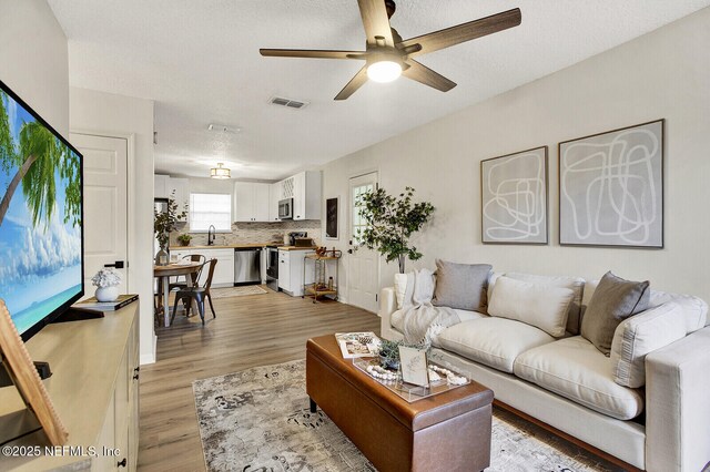 521 Talbot Ave, Jacksonville, FL 32205 - living room featuring a ceiling fan and light wood-style floors
