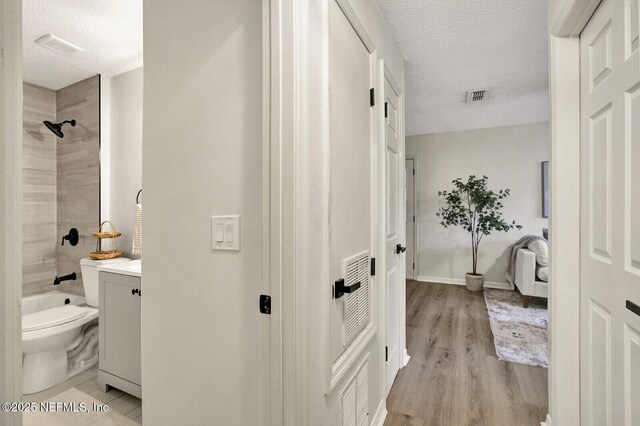 521 Talbot Ave, Jacksonville, FL 32205 - full bath featuring toilet, vanity, wood finished floors, a textured ceiling, and bathing tub / shower combination