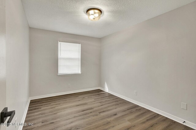 521 Talbot Ave, Jacksonville, FL 32205 - empty room featuring wood finished floors, a textured ceiling, and baseboards
