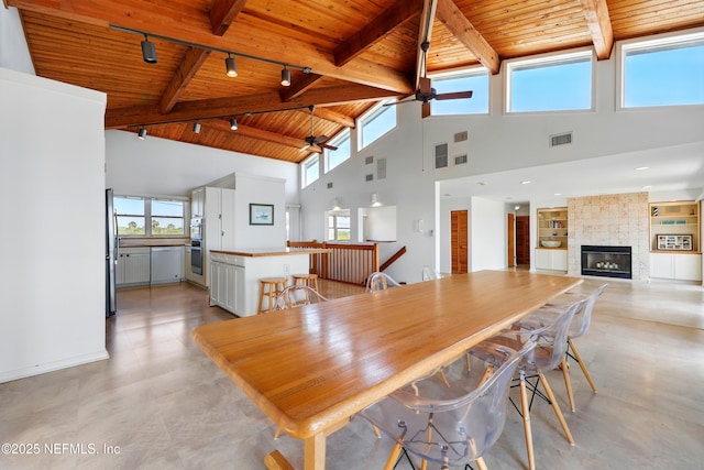 2605 S Ponte Vedra Blvd, Ponte Vedra Beach, FL 32082 - dining space featuring wooden ceiling with exposed beams, rail lighting, a ceiling fan, high vaulted ceiling, and a large fireplace