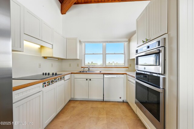 2605 S Ponte Vedra Blvd, Ponte Vedra Beach, FL 32082 - kitchen featuring stainless steel appliances, a sink, light countertops, beamed ceiling, and white cabinetry
