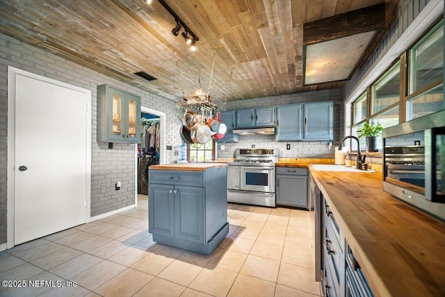 153 Jaffa Rd, Crescent City, FL 32112 - kitchen featuring butcher block countertops, double oven range, a sink, under cabinet range hood, and wooden ceiling