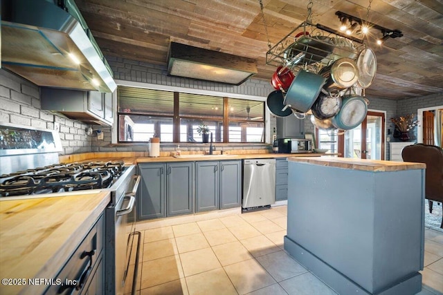 153 Jaffa Rd, Crescent City, FL 32112 - kitchen with appliances with stainless steel finishes, wall chimney exhaust hood, butcher block counters, wood ceiling, and a sink