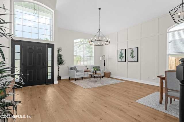 1008 Durbin Parke Dr, Saint Johns, FL 32259 - entrance foyer with a chandelier, light wood-style floors, a decorative wall, baseboards, and a towering ceiling