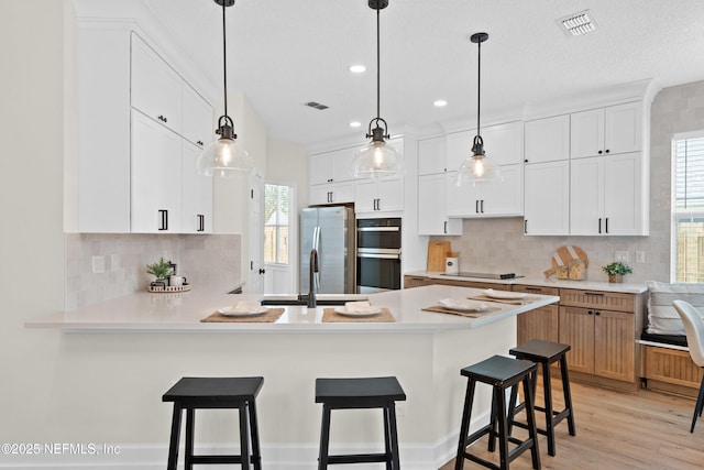 1008 Durbin Parke Dr, Saint Johns, FL 32259 - kitchen with freestanding refrigerator, light countertops, decorative backsplash, a peninsula, and recessed lighting