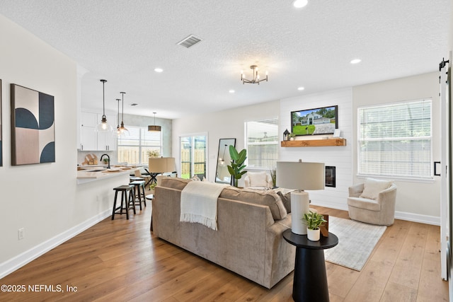 1008 Durbin Parke Dr, Saint Johns, FL 32259 - living area featuring light wood finished floors, baseboards, recessed lighting, a textured ceiling, and a fireplace
