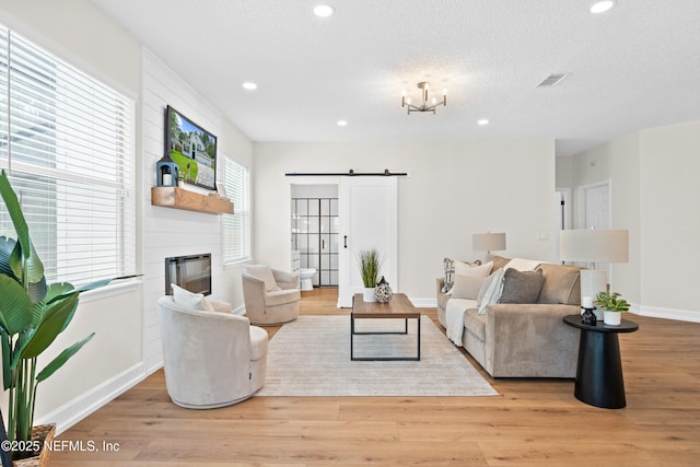 1008 Durbin Parke Dr, Saint Johns, FL 32259 - living room with wood finished floors, baseboards, a fireplace, a barn door, and recessed lighting