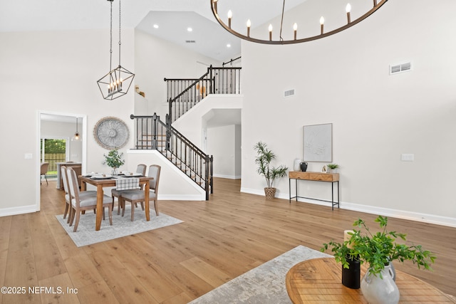 1008 Durbin Parke Dr, Saint Johns, FL 32259 - dining area with a chandelier, stairway, a towering ceiling, light wood-style flooring, and baseboards