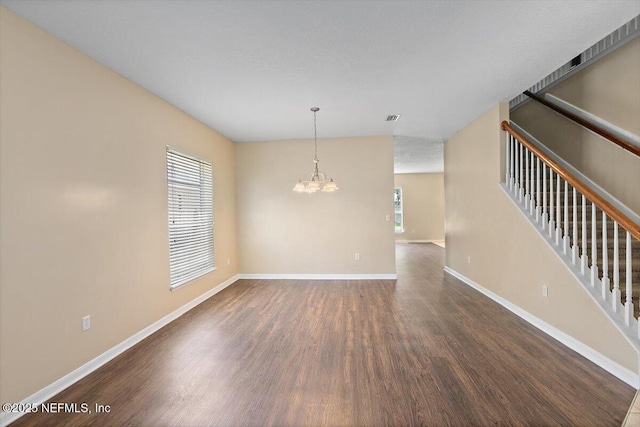 1147 Hyacinth St, Saint Augustine, FL 32092 - unfurnished room featuring dark wood-style flooring, a chandelier, baseboards, and stairs