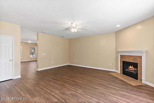 1147 Hyacinth St, Saint Augustine, FL 32092 - unfurnished living room featuring wood finished floors, ceiling fan, a tile fireplace, baseboards, and a textured ceiling