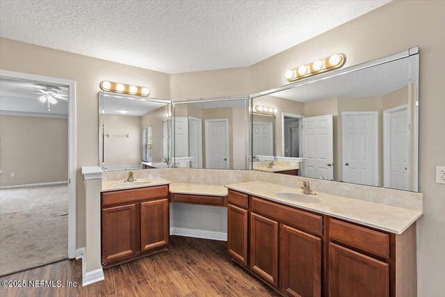 1147 Hyacinth St, Saint Augustine, FL 32092 - bathroom featuring double vanity, wood finished floors, a textured ceiling, a ceiling fan, and baseboards