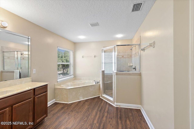 1147 Hyacinth St, Saint Augustine, FL 32092 - bathroom with vanity, wood finished floors, a shower stall, a textured ceiling, and a bath