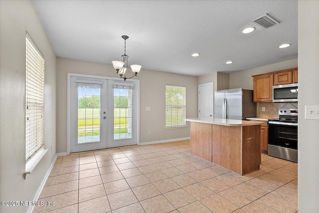 4952 Cypress Links Blvd, Elkton, FL 32033 - kitchen featuring stainless steel appliances, baseboards, tasteful backsplash, light countertops, and a kitchen island