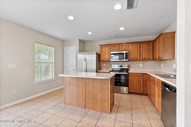 4952 Cypress Links Blvd, Elkton, FL 32033 - kitchen with stainless steel appliances, a sink, tasteful backsplash, a center island, and light countertops