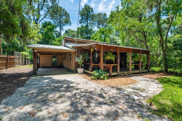 9160 Wild Rd, Jacksonville, FL 32220 - view of front of property featuring gravel driveway, an attached carport, and metal roof