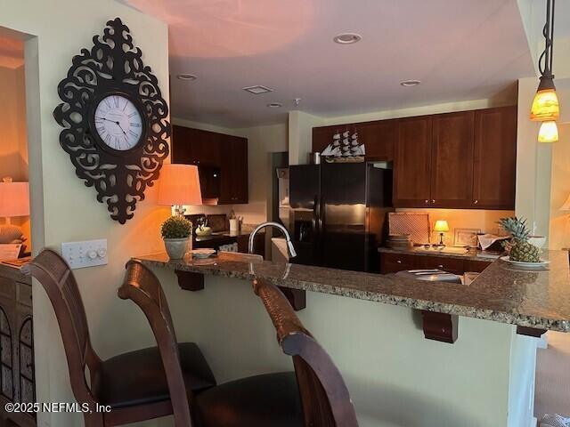 955 Registry Blvd Unit 229, Saint Augustine, FL 32092 - kitchen with black fridge, a peninsula, dark stone countertops, a breakfast bar, and recessed lighting