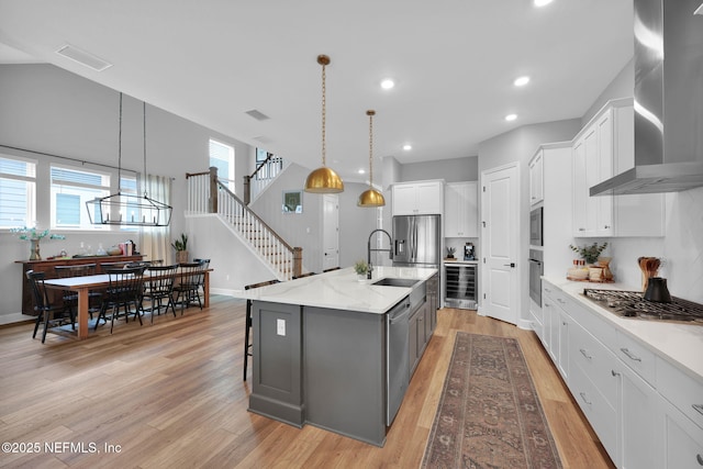 95 Farmers Branch Ave, Ponte Vedra, FL 32081 - kitchen featuring wall chimney range hood, stainless steel appliances, beverage cooler, a sink, and light wood finished floors