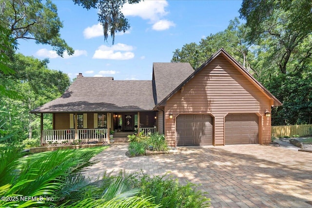 404 Camelia Trl, Saint Augustine, FL 32086 - view of front facade with covered porch, an attached garage, a shingled roof, driveway, and a chimney