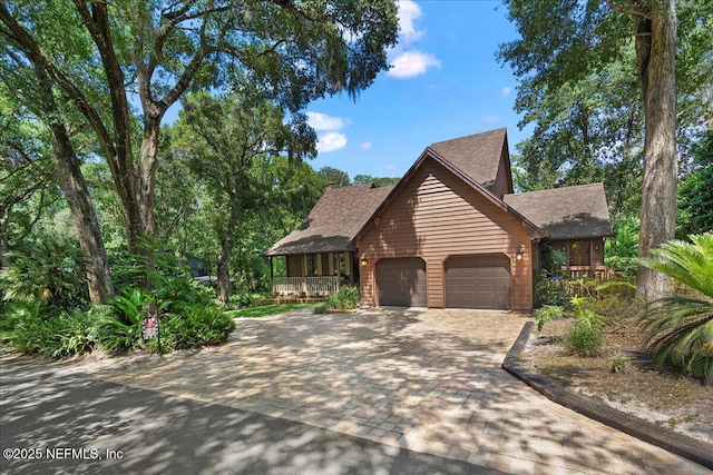 404 Camelia Trl, Saint Augustine, FL 32086 - rustic home featuring a garage, roof with shingles, decorative driveway, and a porch