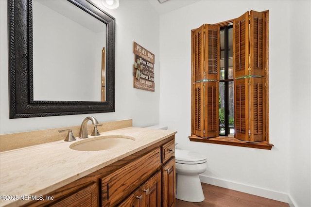 404 Camelia Trl, Saint Augustine, FL 32086 - bathroom featuring toilet, vanity, wood finished floors, and baseboards