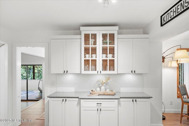 404 Camelia Trl, Saint Augustine, FL 32086 - kitchen with white cabinets, backsplash, glass insert cabinets, and light wood-style flooring