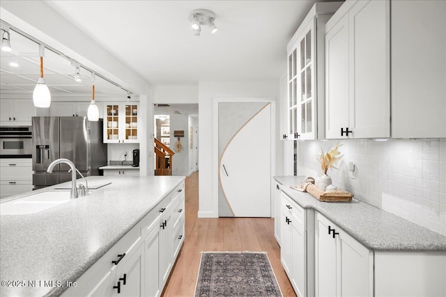 404 Camelia Trl, Saint Augustine, FL 32086 - kitchen featuring stainless steel appliances, a sink, light wood-style floors, tasteful backsplash, and white cabinets