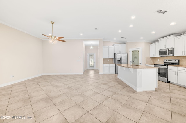 305 Green Turtle Ln, Saint Augustine, FL 32086 - kitchen with appliances with stainless steel finishes, a sink, crown molding, backsplash, and an island with sink