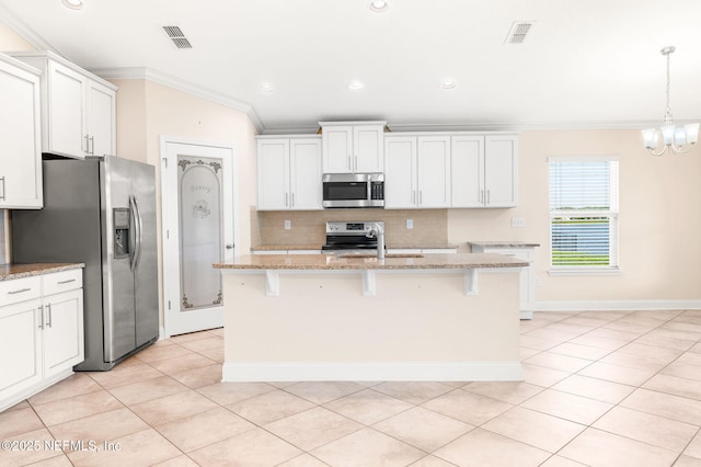305 Green Turtle Ln, Saint Augustine, FL 32086 - kitchen featuring stainless steel appliances, crown molding, backsplash, light tile patterned floors, and a breakfast bar area