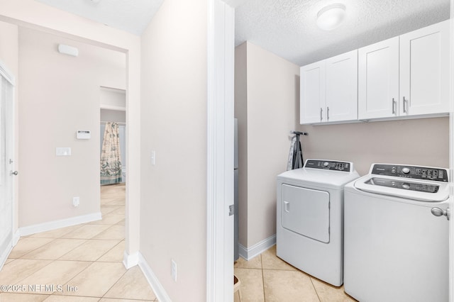 305 Green Turtle Ln, Saint Augustine, FL 32086 - laundry area with cabinet space, washer and clothes dryer, light tile patterned flooring, baseboards, and a textured ceiling