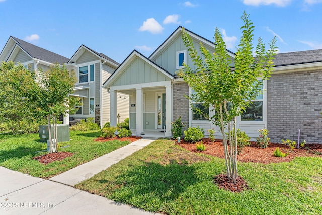 68 Cabana Dr, Ponte Vedra, FL 32081 - view of front of house featuring board and batten siding, a front lawn, brick siding, and covered porch