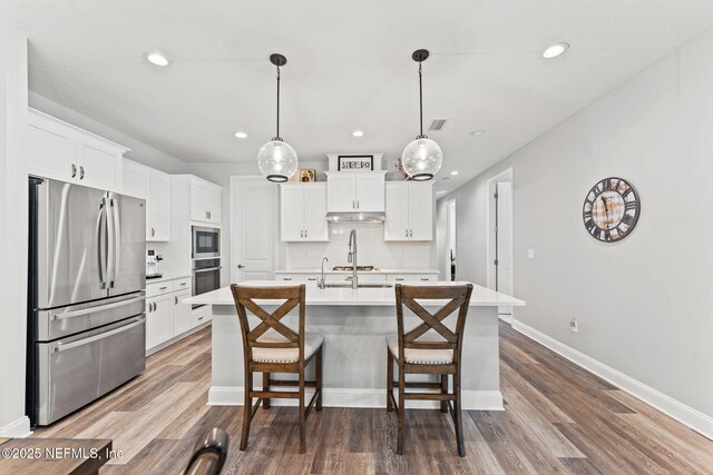 68 Cabana Dr, Ponte Vedra, FL 32081 - kitchen featuring stainless steel appliances, recessed lighting, light countertops, a center island with sink, and white cabinets