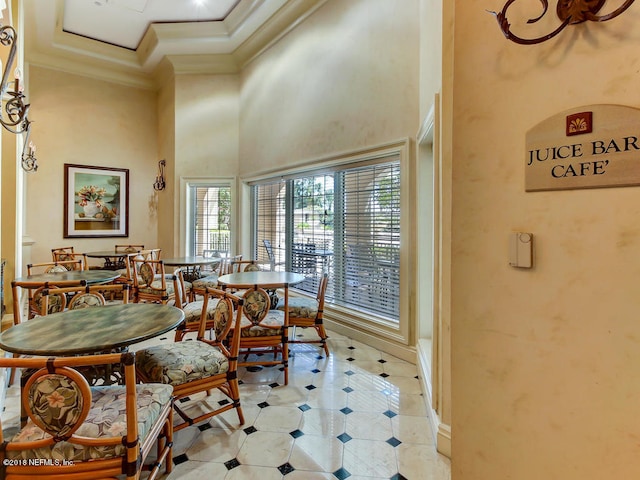 400 E Bay St Unit 1010, Jacksonville, FL 32202 - dining room with ornamental molding, a towering ceiling, light tile patterned floors, baseboards, and inlaid floor details