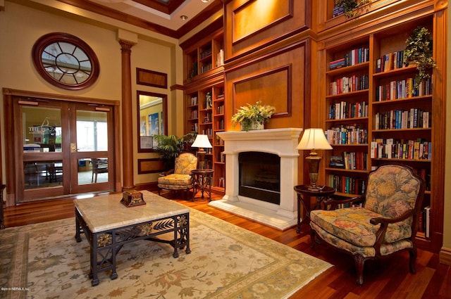 400 E Bay St Unit 1010, Jacksonville, FL 32202 - sitting room with built in features, wood finished floors, a fireplace with raised hearth, and crown molding
