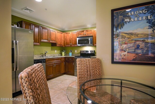 400 E Bay St Unit 1010, Jacksonville, FL 32202 - kitchen with appliances with stainless steel finishes, a sink, crown molding, light countertops, and light tile patterned floors