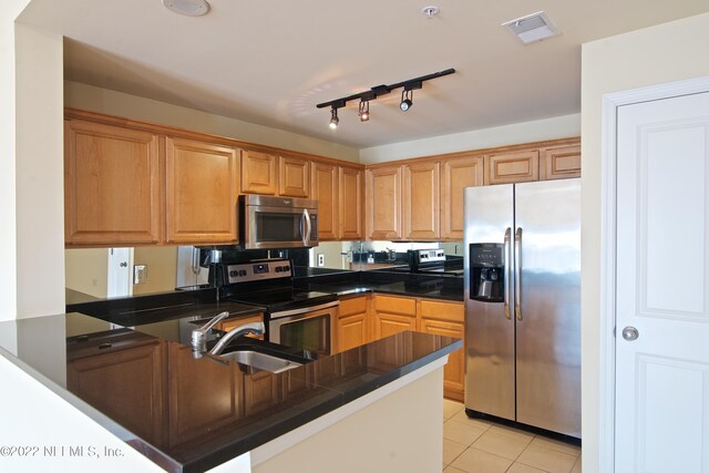 400 E Bay St Unit 1010, Jacksonville, FL 32202 - kitchen featuring appliances with stainless steel finishes, a sink, dark countertops, light tile patterned floors, and a peninsula