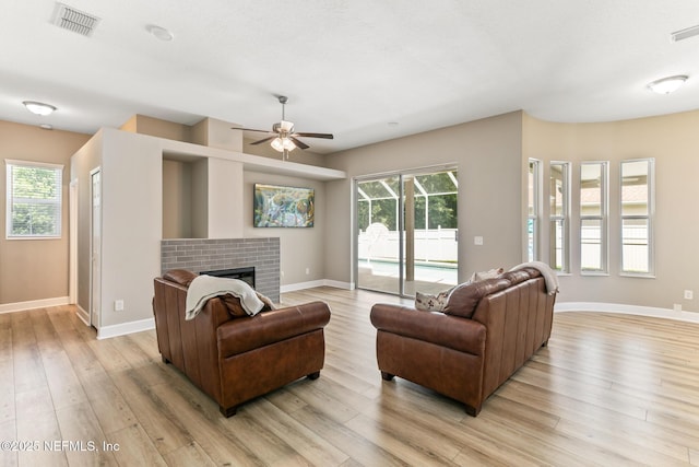 3820 Danforth Dr W, Jacksonville, FL 32224 - living area with light wood-style floors, baseboards, ceiling fan, and a fireplace
