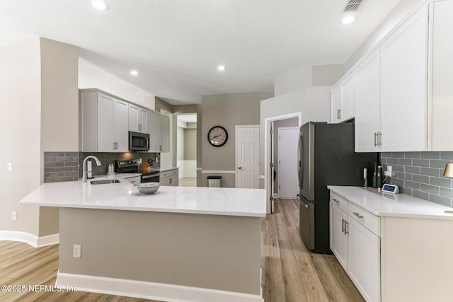 3820 Danforth Dr W, Jacksonville, FL 32224 - kitchen featuring stainless steel appliances, a sink, a peninsula, light wood finished floors, and recessed lighting