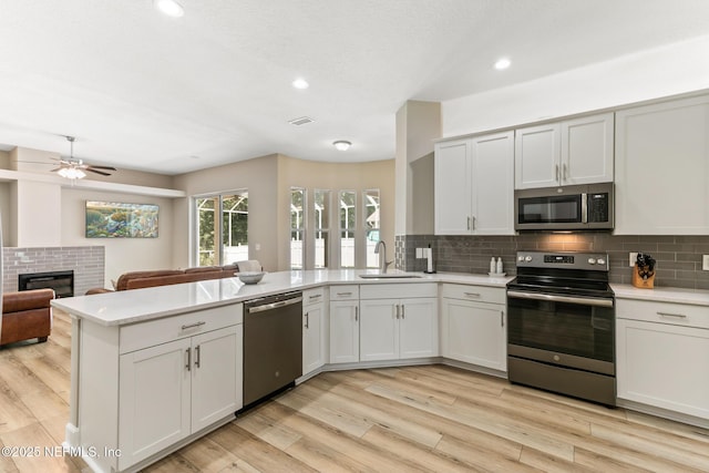 3820 Danforth Dr W, Jacksonville, FL 32224 - kitchen with stainless steel appliances, a sink, a peninsula, decorative backsplash, and light countertops