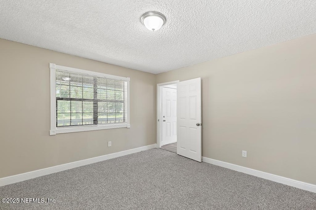 2718 Parkrus Ln, Jacksonville, FL 32208 - unfurnished bedroom featuring carpet floors, a textured ceiling, and baseboards