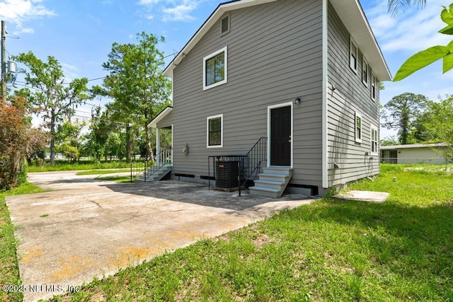 2718 Parkrus Ln, Jacksonville, FL 32208 - rear view of house featuring entry steps, a lawn, and central AC