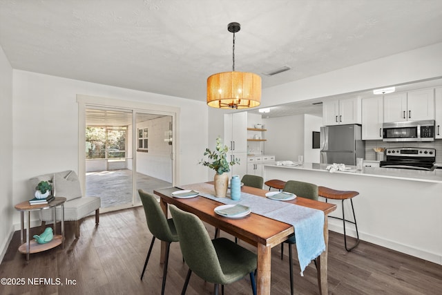 364 Aries Dr, Orange Park, FL 32073 - dining room with a chandelier, dark wood finished floors, and baseboards