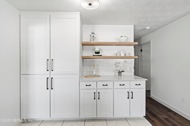 364 Aries Dr, Orange Park, FL 32073 - indoor bar with backsplash, baseboards, light wood-style floors, and a textured ceiling