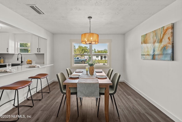 364 Aries Dr, Orange Park, FL 32073 - dining space with dark wood-type flooring, baseboards, a textured ceiling, and a chandelier