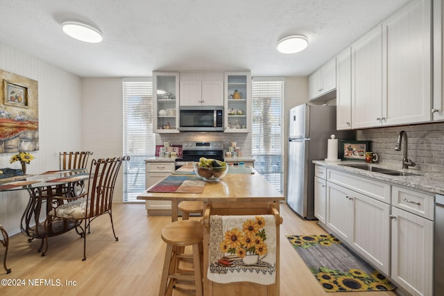 901 Ocean Blvd Unit 98, Atlantic Beach, FL 32233 - kitchen featuring appliances with stainless steel finishes, a sink, decorative backsplash, healthy amount of natural light, and a textured ceiling