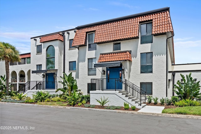 2327 Costa Verde Blvd Unit 201, Jacksonville Beach, FL 32250 - view of front of property featuring a tiled roof, stucco siding, and mansard roof