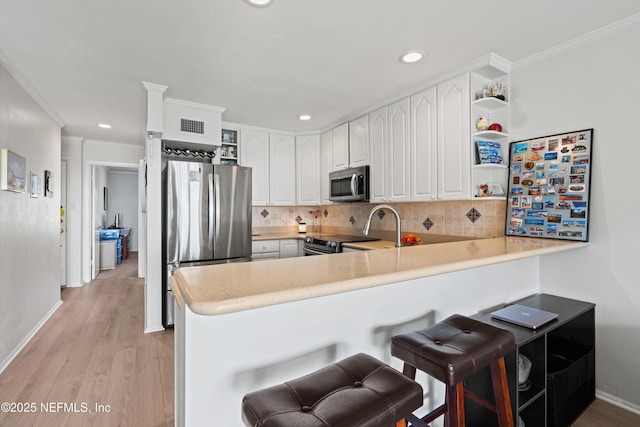 2327 Costa Verde Blvd Unit 201, Jacksonville Beach, FL 32250 - kitchen with stainless steel appliances, open shelves, a peninsula, backsplash, and white cabinetry