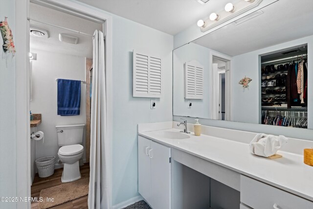 2327 Costa Verde Blvd Unit 201, Jacksonville Beach, FL 32250 - bathroom featuring vanity, wood finished floors, toilet, a spacious closet, and curtained shower
