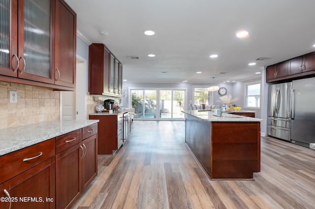 5253 Royce Ave, Jacksonville, FL 32205 - kitchen featuring freestanding refrigerator, light wood-style floors, stainless steel refrigerator, recessed lighting, and tasteful backsplash